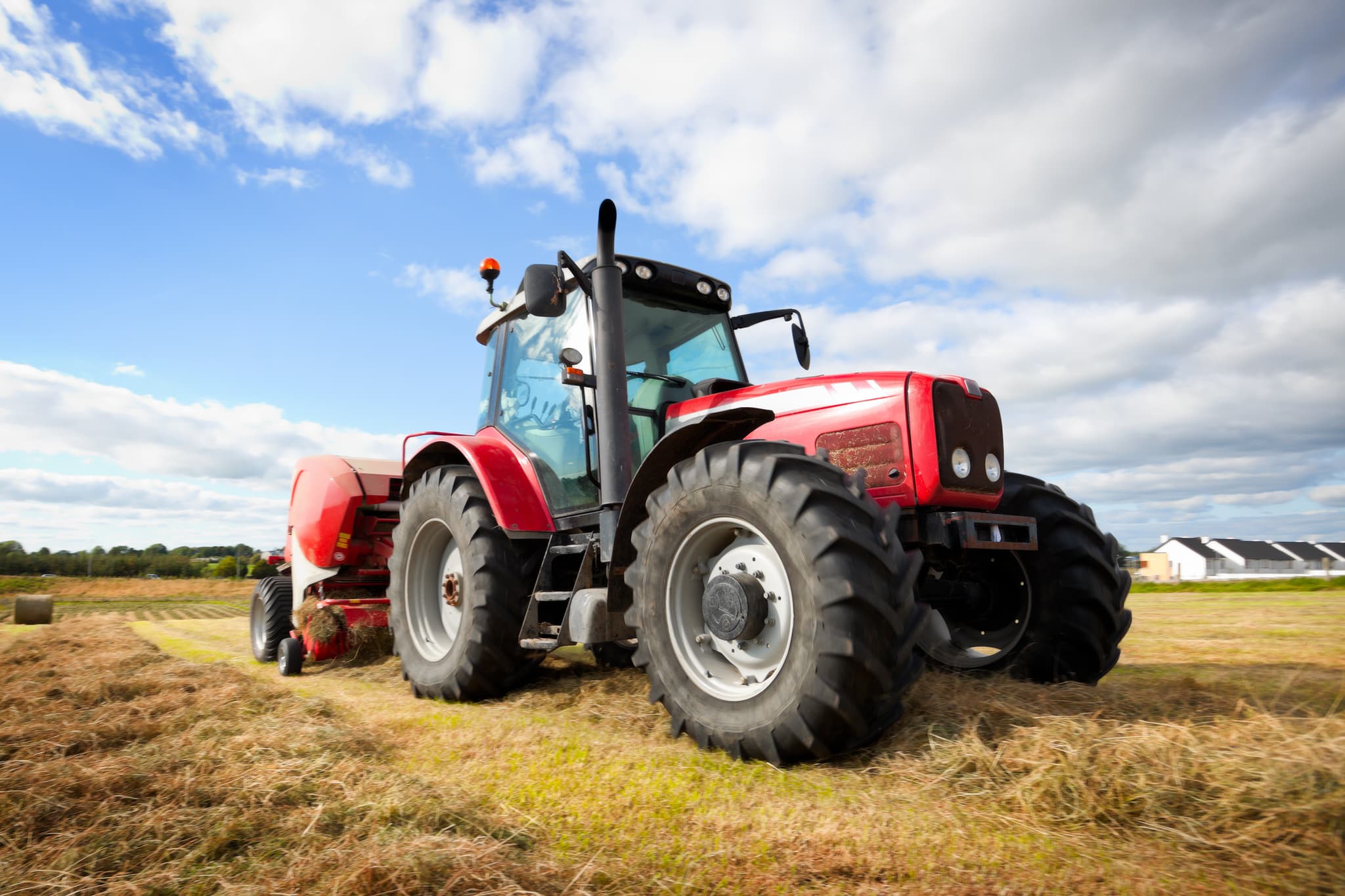 Red tractor cutting grass
