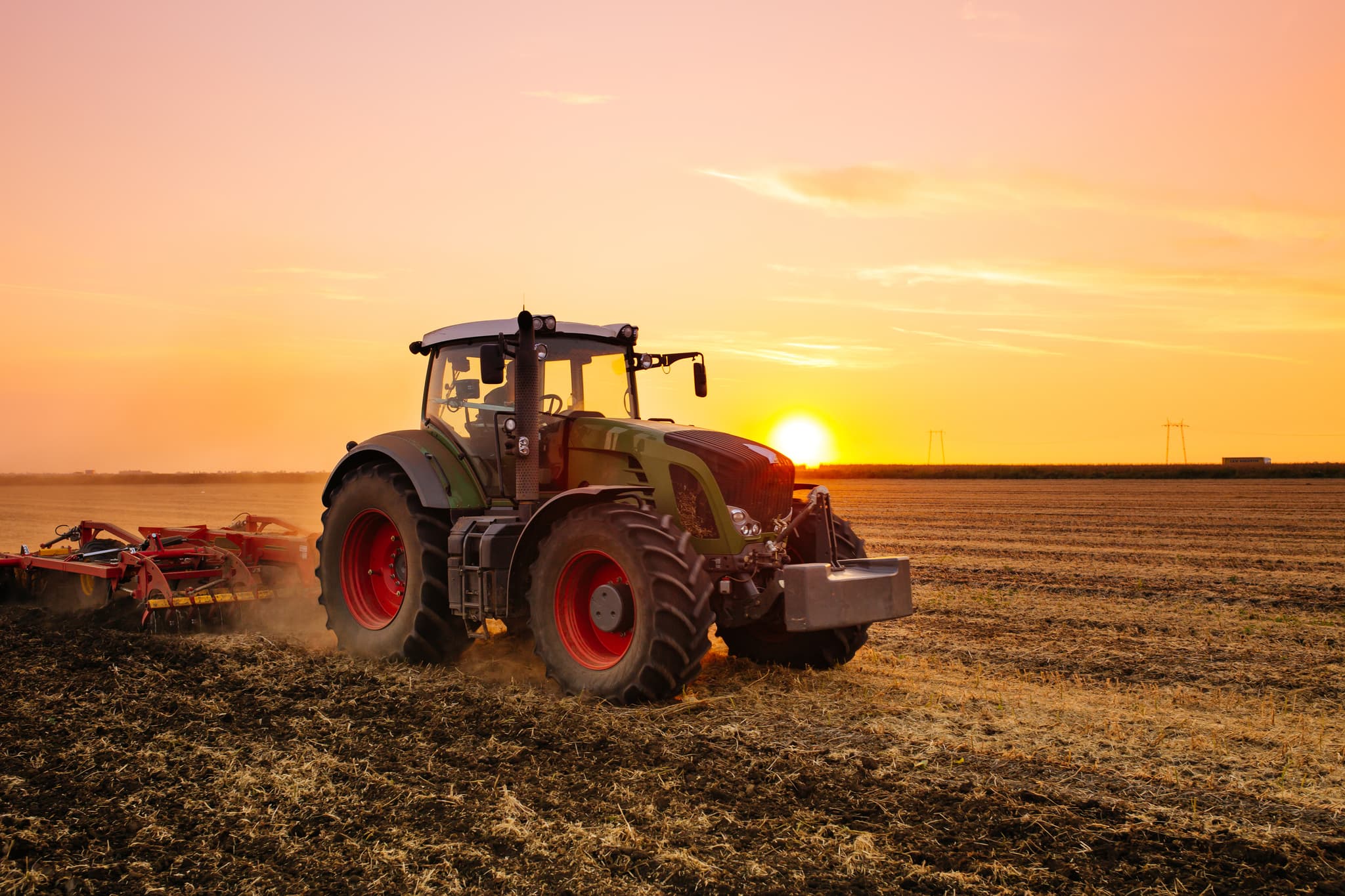 Red tractor making the soil in the evening